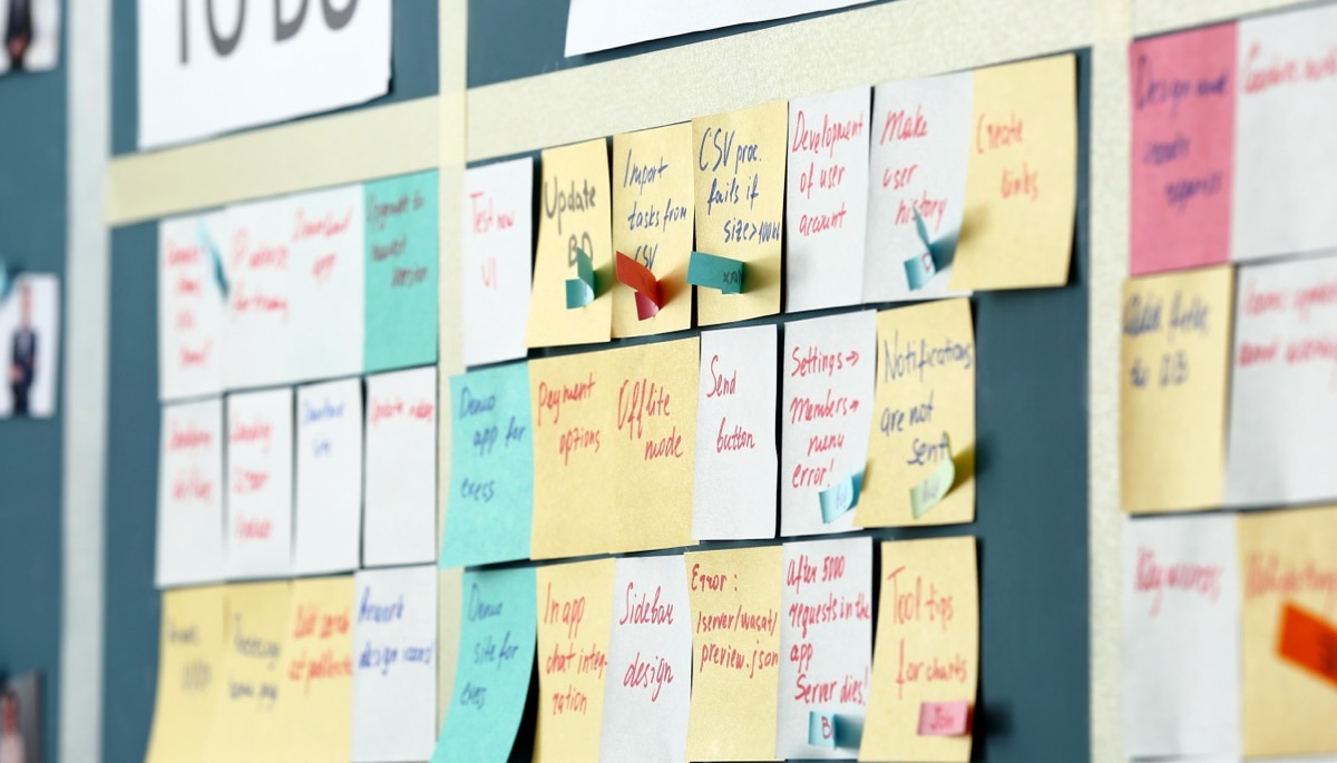 A planning board covered in sticky notes under To Do and In Progress columns