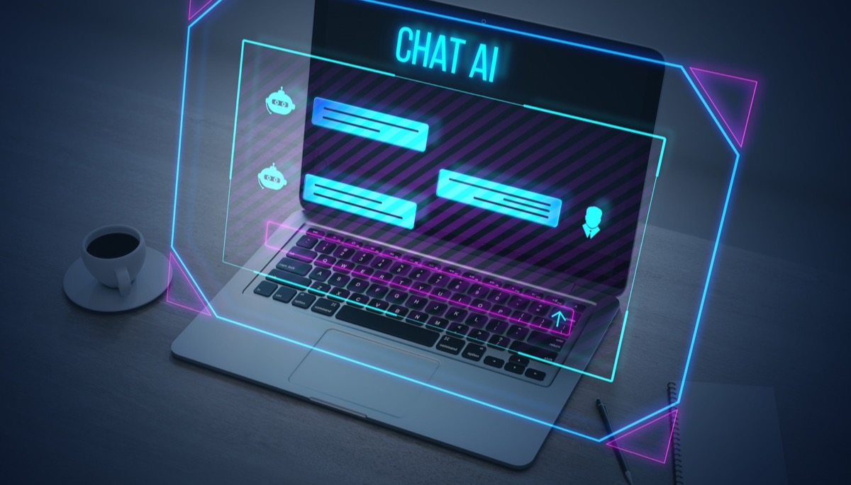 A laptop on a desk with a glowing Chat AI interface hovering over the screen