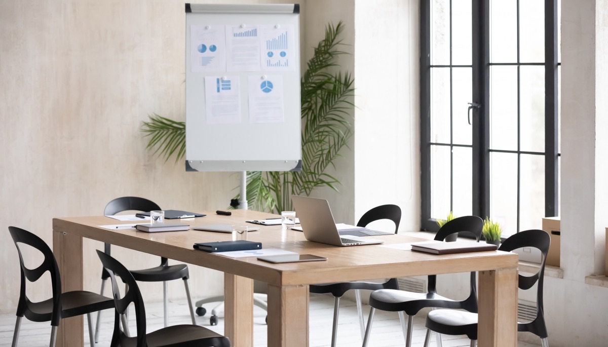 An empty meeting room with a flip chart showing statistics and diagrams