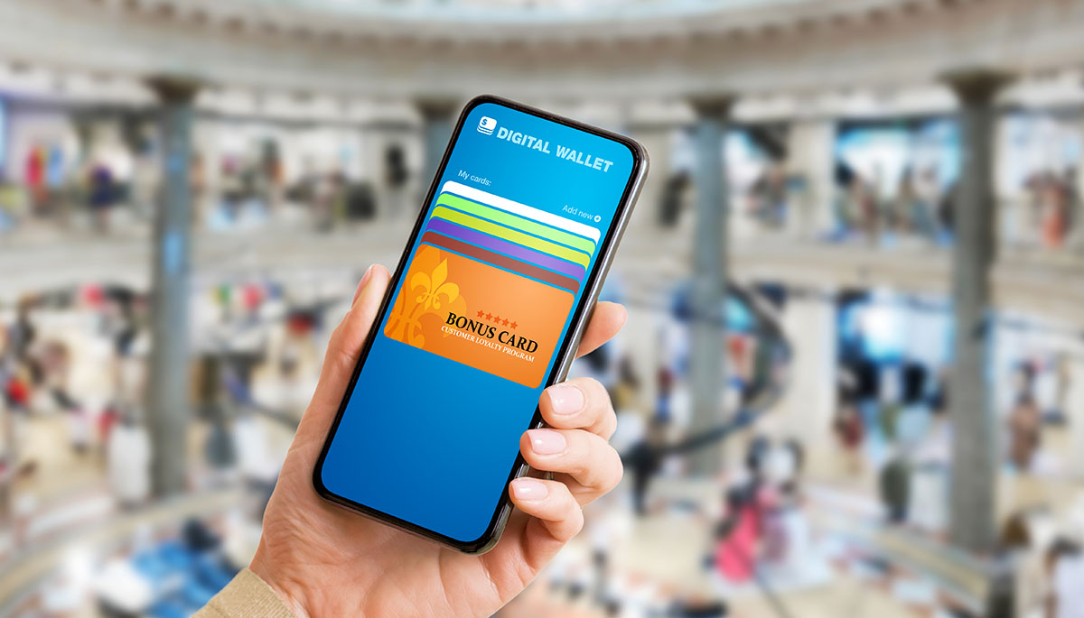 A hand holding a smartphone showing a digital wallet with a customer loyalty bonus card